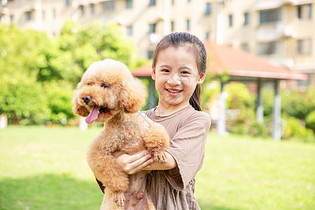 小女孩户外遛狗和狗玩耍图片