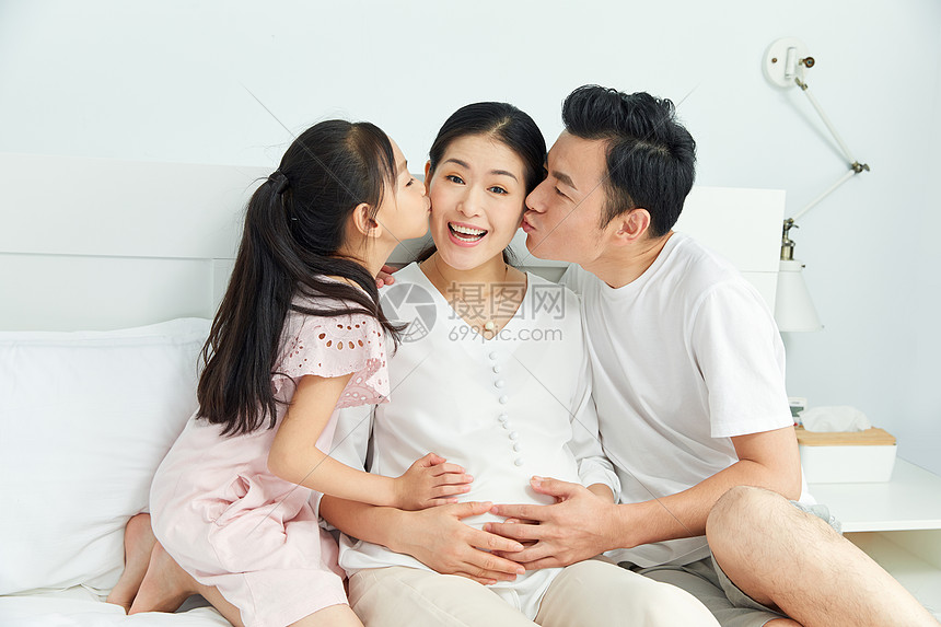 小女孩和爸爸一起亲吻孕妇妈妈图片