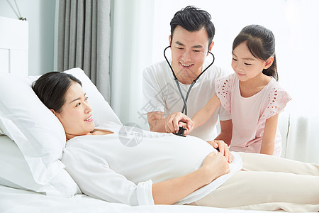 准爸爸拿听诊器听孕妇老婆胎动图片