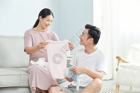 孕妇和丈夫在家收拾婴儿服饰图片