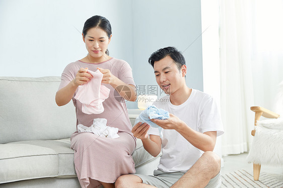 孕妇和丈夫在家收拾婴儿服饰图片