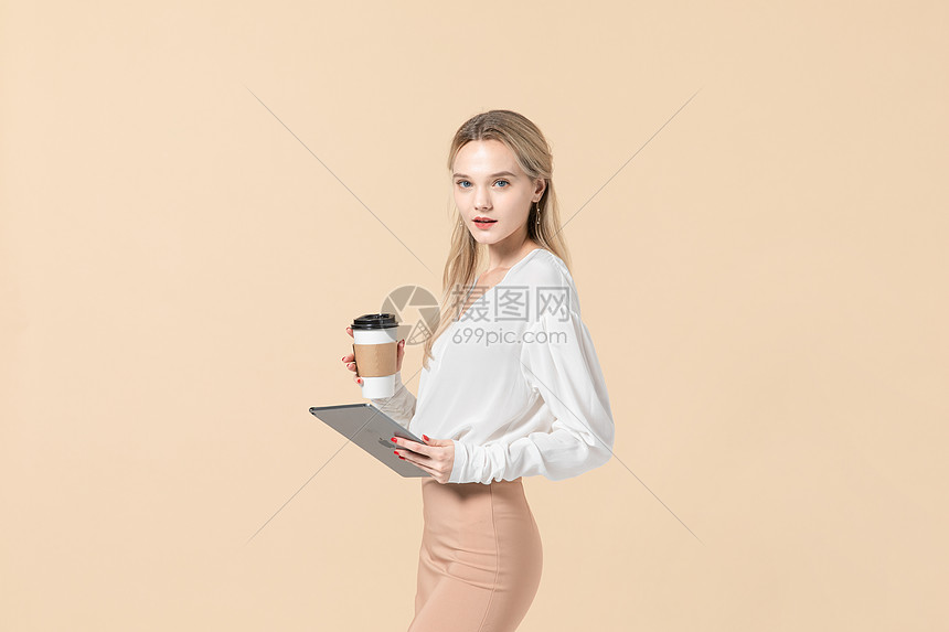 拿着平板电脑和咖啡杯的外国女模特图片