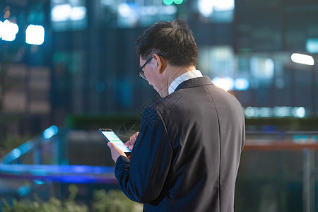 夜景商务男性加班使用手机背影图片