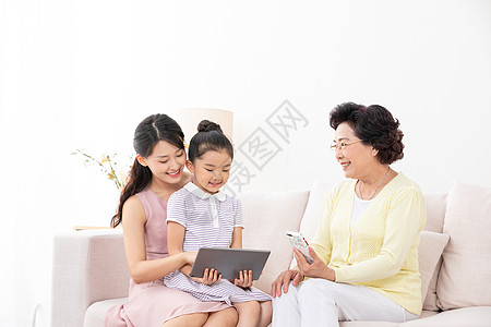 祖孙三代人坐在沙发上看iPad背景