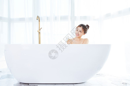 年轻女性在浴缸洗澡图片