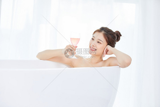 美女躺在浴缸洗泡泡浴喝鸡尾酒图片