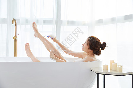 年轻女性泡澡刮腿毛图片