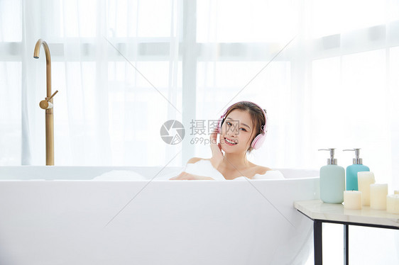 年轻女性洗泡泡浴听音乐图片