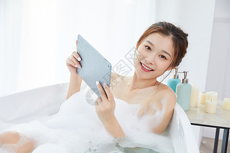 美女洗泡泡浴玩平板电脑图片素材