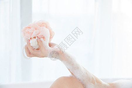 年轻女性使用洗浴球洗澡特写图片