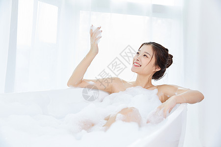 时尚女性在护肤女性躺在浴缸里洗泡泡浴背景