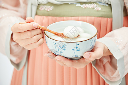 蹲着的古风女孩汉服美女手端着一碗汤圆背景