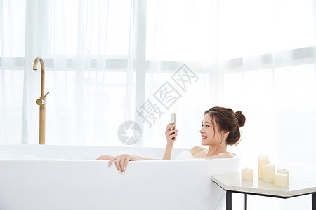 美女洗泡泡浴玩手机高清图片
