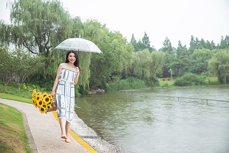 雨中撑伞提花的少女图片