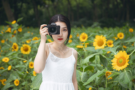 向日葵中拿着相机的少女图片