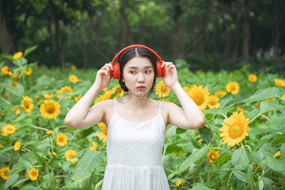 向日葵中戴耳机的少女图片