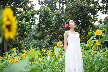 向日葵中戴耳机的少女图片