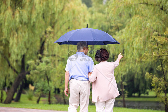 老年夫妇雨中散步背影图片