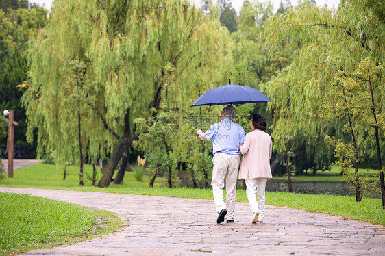 老年夫妇雨中散步背影图片