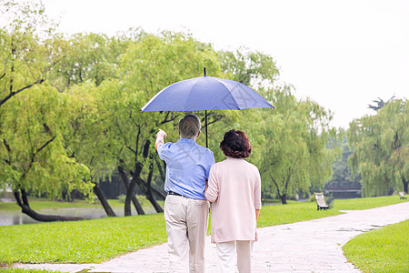 老年人散步老年夫妇雨中散步背影背景