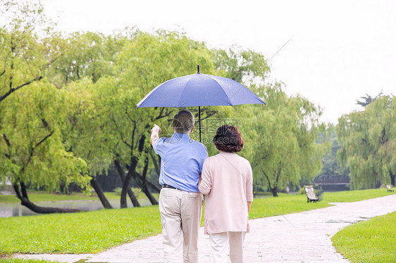 老年夫妇雨中散步背影图片