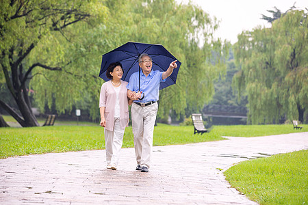 老年夫妇在公园雨中散步图片