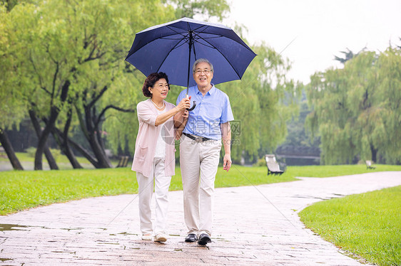 老年夫妇在公园雨中散步图片