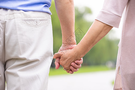 老人夫妻老年夫妇出游牵手特写背景