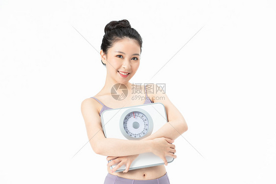 运动美女手拿体重秤图片