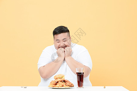 青年肥胖男性吃炸鸡图片素材