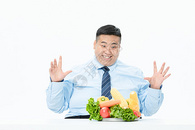商务肥胖男性吃蔬菜图片
