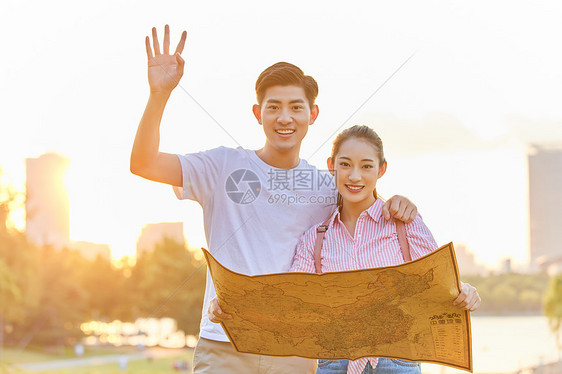 年轻情侣拿着地图旅行图片