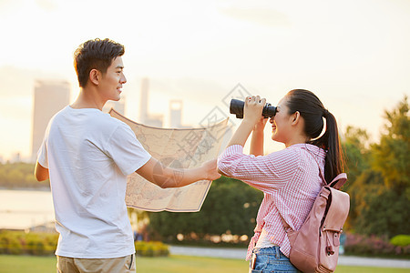 年轻情侣拿着地图旅行图片