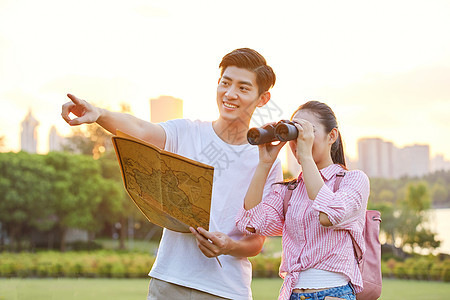 年轻情侣拿着地图旅行背景图片