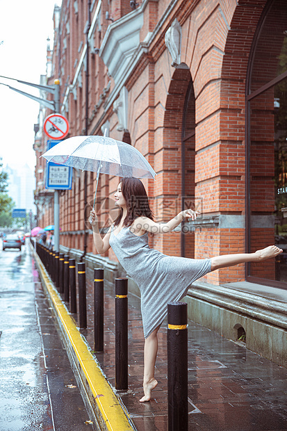 在街上撑伞跳舞的女性图片