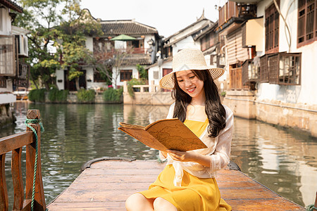 年轻美女乘船郊游看地图图片