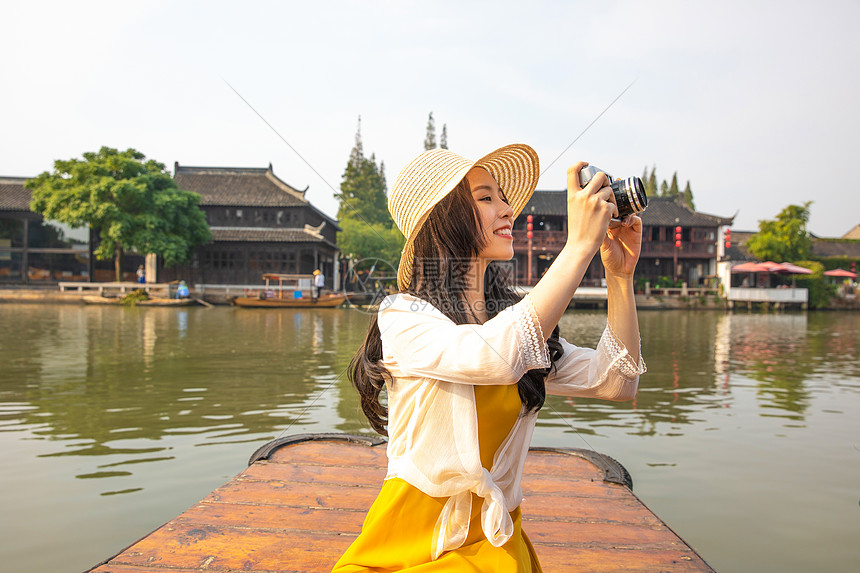 年轻美女乘船郊游拍照图片