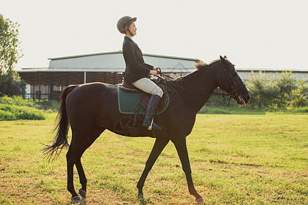 年轻女子户外骑马背景图片