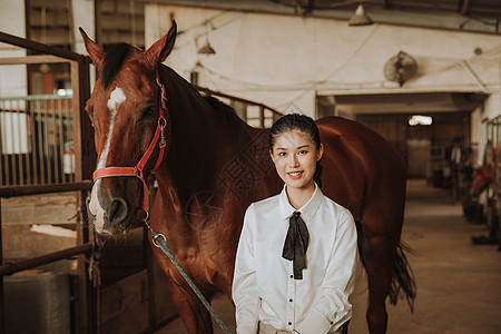 青年女性马厩牵马背景图片