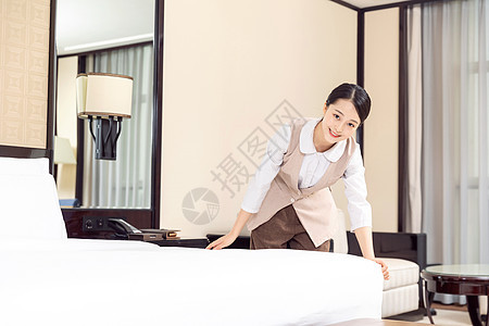 酒店管理保洁员整理床铺背景图片
