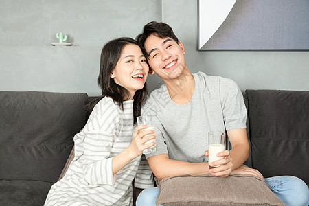 可爱青年夫妻沙发上喝豆浆图片