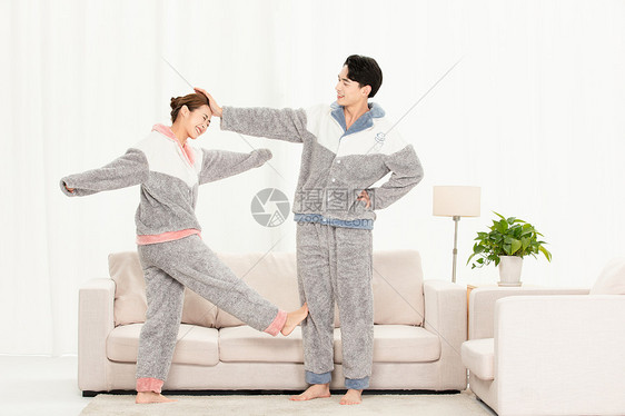 年轻情侣穿睡衣居家锻炼身体图片