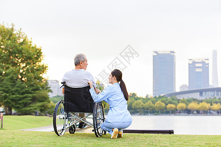 男人坐在轮椅上护工照顾老人背影背景