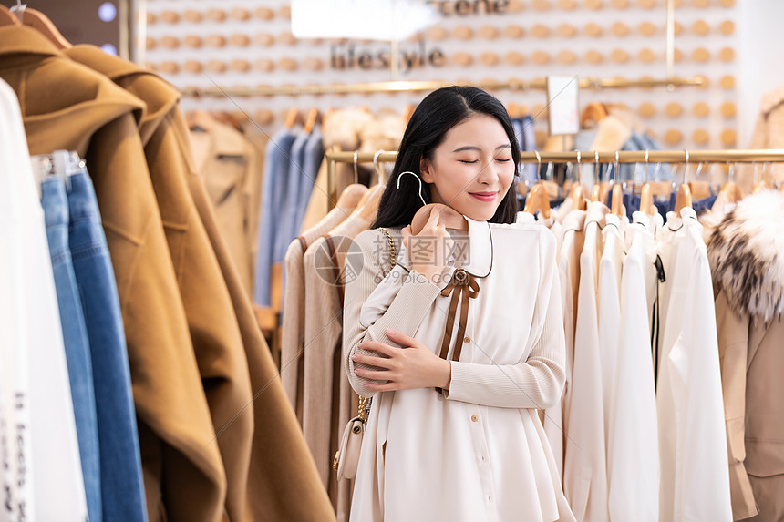 年轻美女商场购物挑选衣服图片