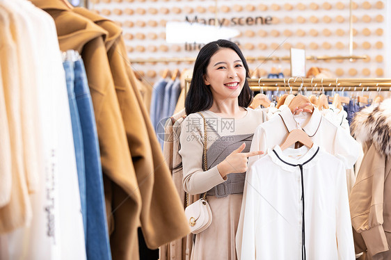 年轻美女商场购物挑选衣服图片