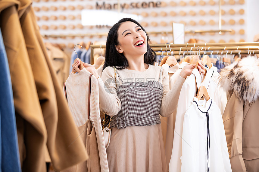 年轻美女商场购物挑选衣服图片