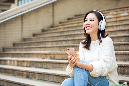 甜美女生户外听音乐走廊高清图片素材