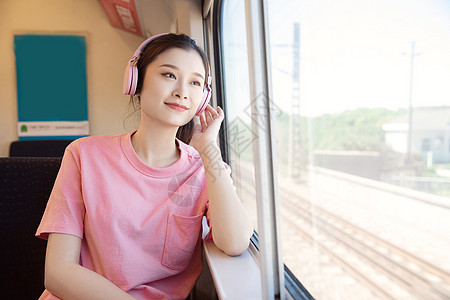 青年女性坐在高铁上听歌图片