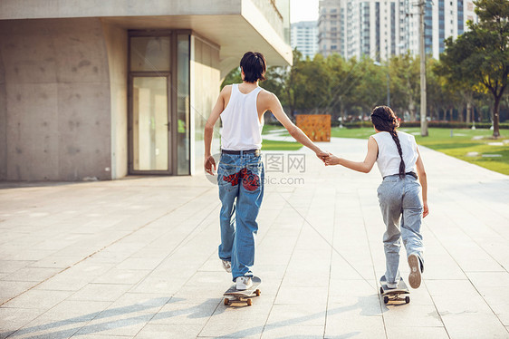 情侣户外玩滑板背影图片