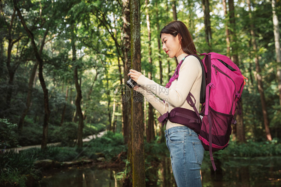 青年女性在森林里拍照图片